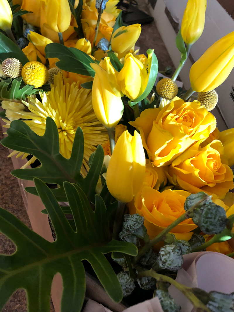 Floral arrangement of yellow tulips, yellow roses, lights in vase - Agnes Verano events
